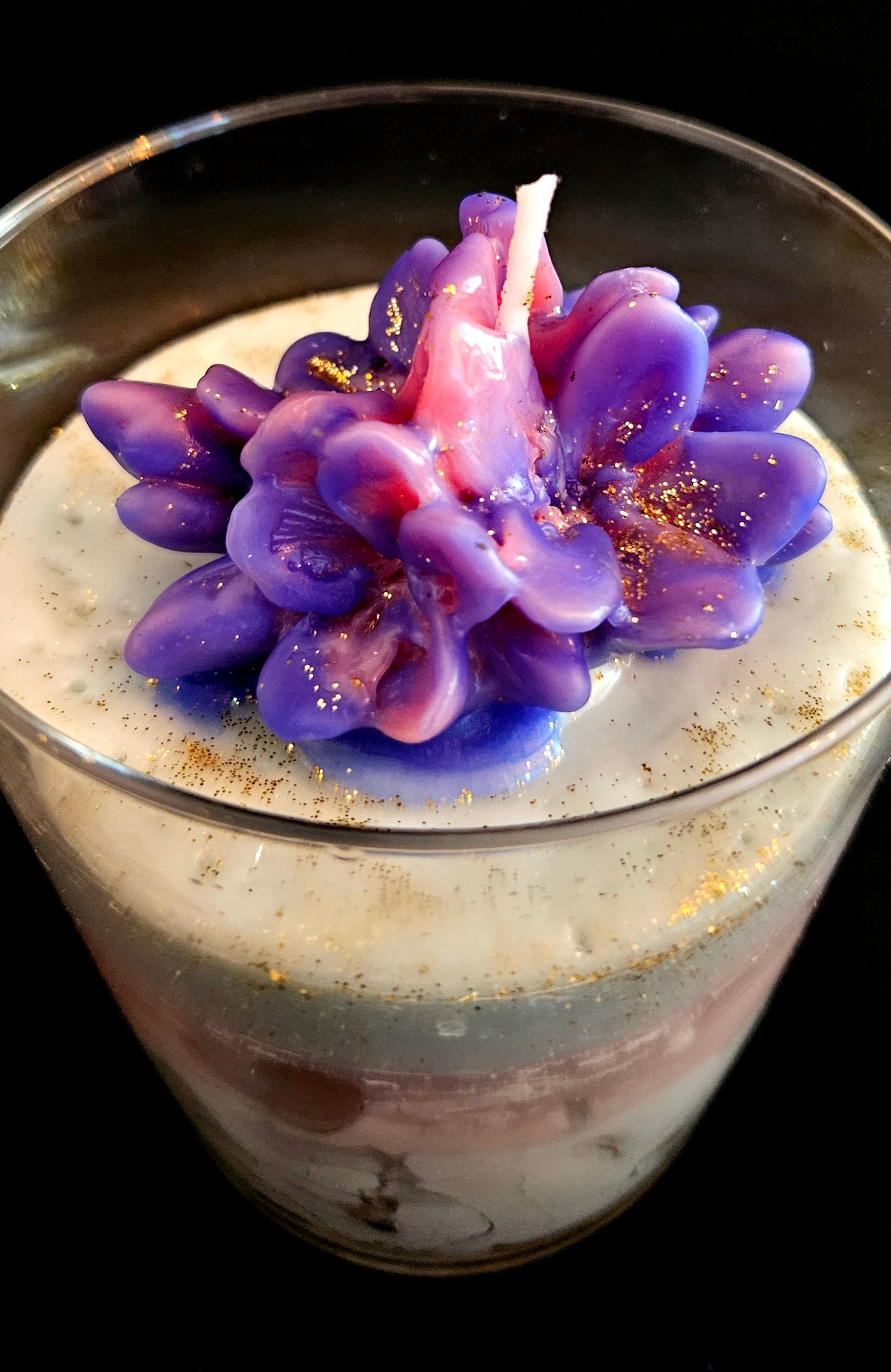 A handmade candle featuring jelly and soy wax, adorned with flowers.