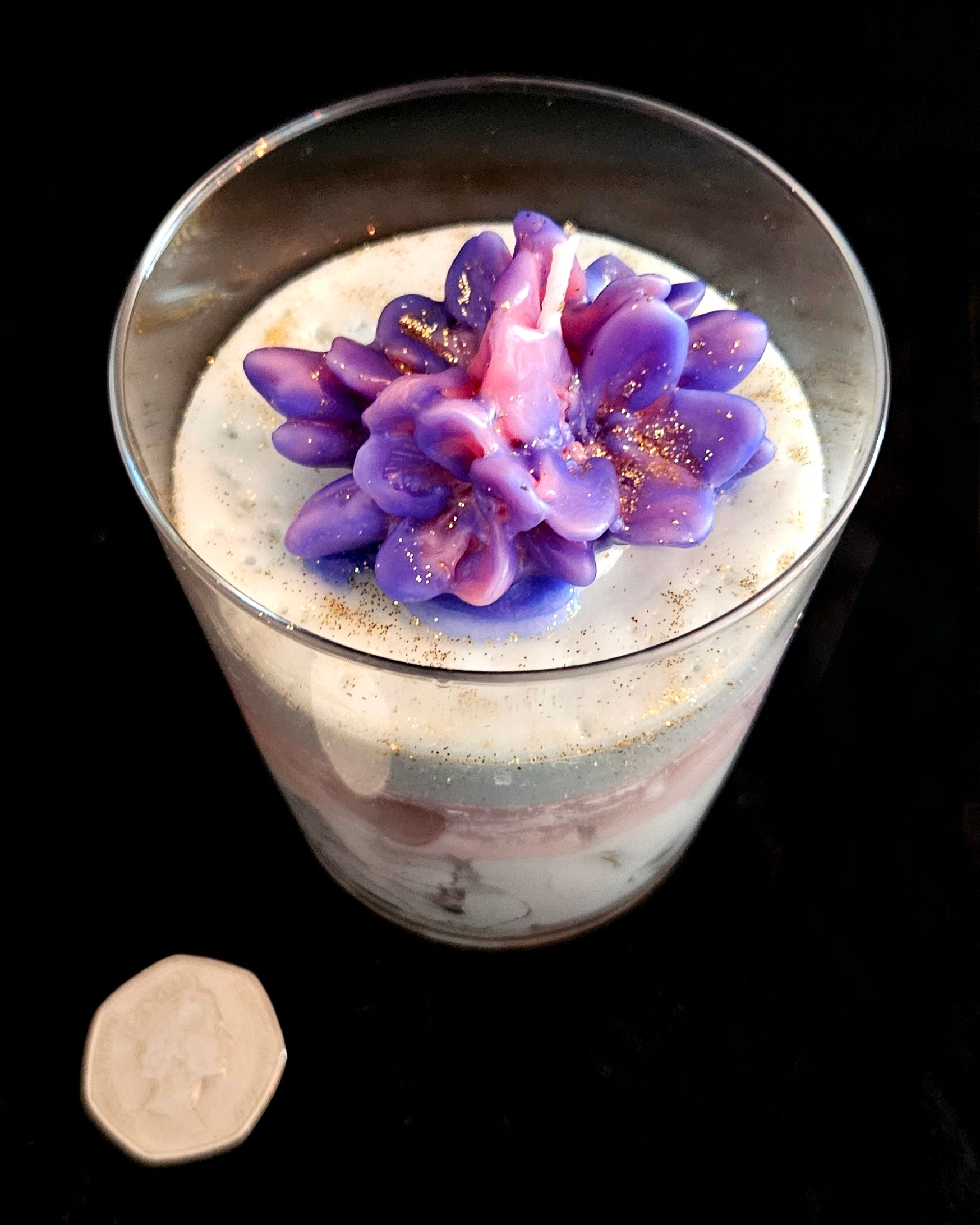 A handmade candle featuring jelly and soy wax, adorned with flowers.